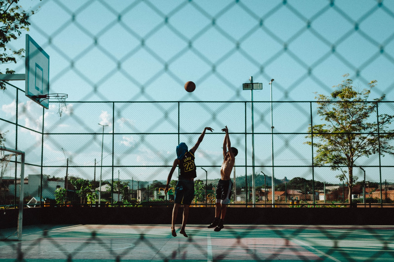 Dois jovens jogam basquete 