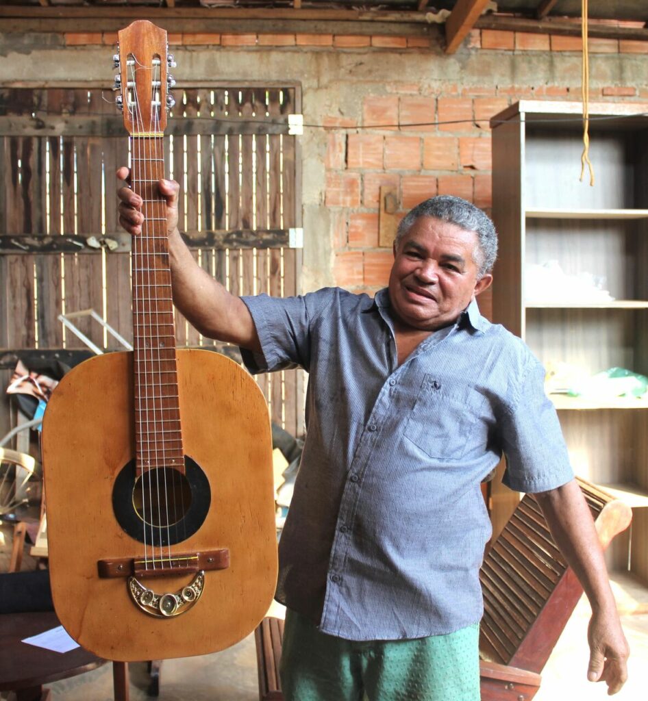 artesão segurando violão em ateliê 